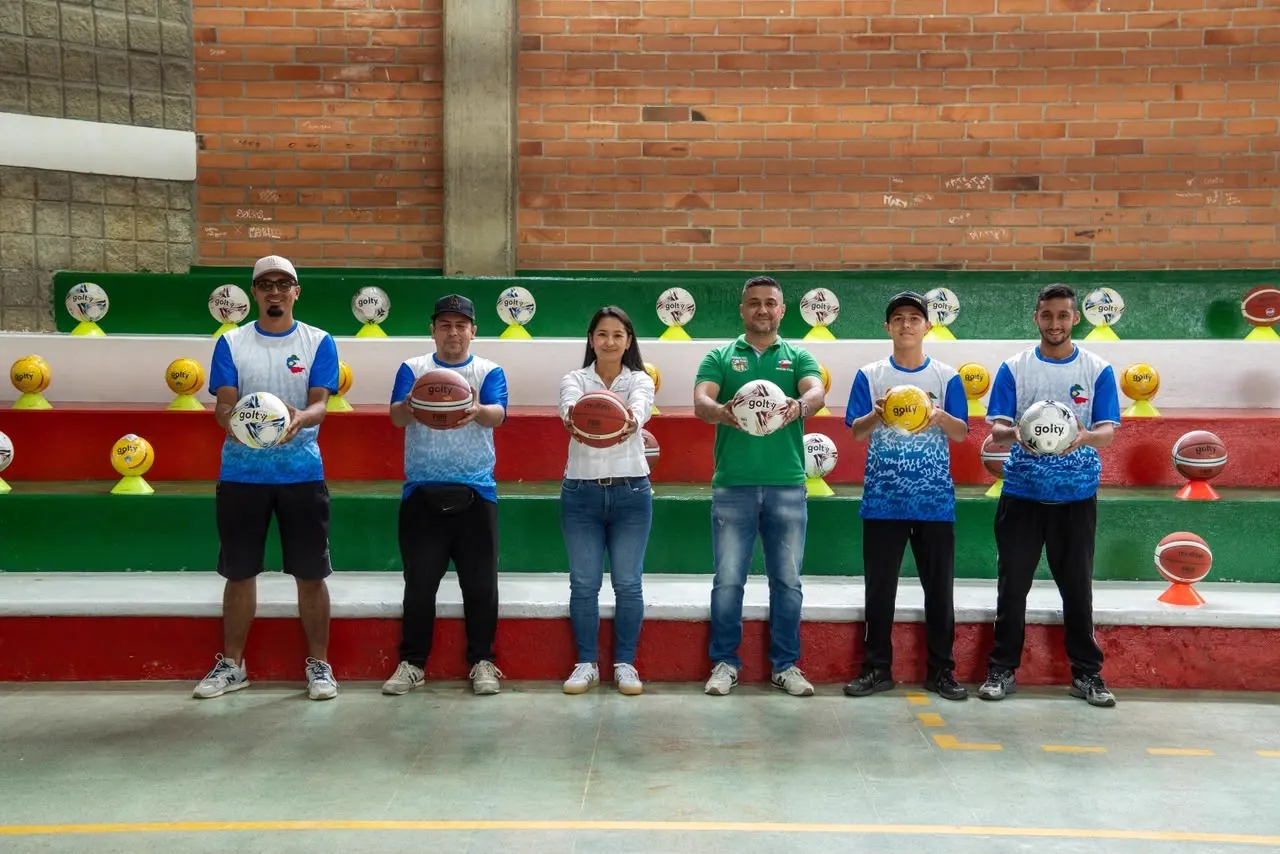 Seis personas de pie frente a unas graderías sostienen balones de baloncesto y de fútbol de salón.